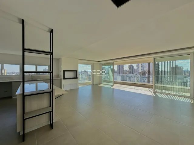 Ambiente interno de uma sala de estar com vista para a cidade.