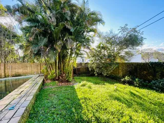 Vista externa de um jardim com vegetação densa e um canal de água.
