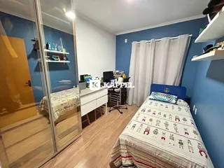 Quarto com cama e escrivaninha em um ambiente com paredes azuis.
