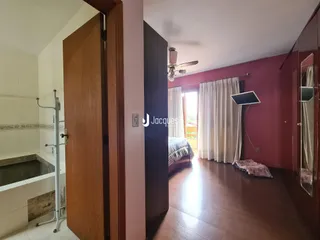 Vista de um corredor que conecta um banheiro e um quarto em uma residência.