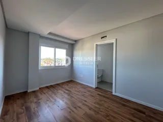 Ambiente interno de uma sala com piso de madeira e janela.
