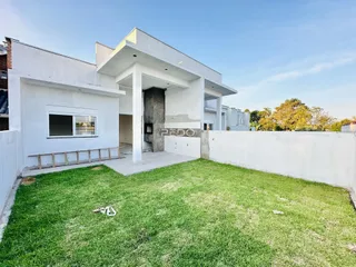 Vista da fachada de uma casa moderna com jardim gramado.