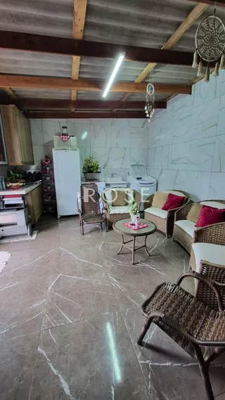 Sala de estar com móveis de vime e piso de mármore na propriedade.