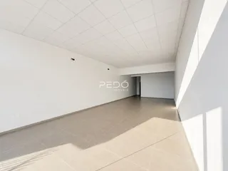 Vista de um corredor interno com piso de cerâmica claro.