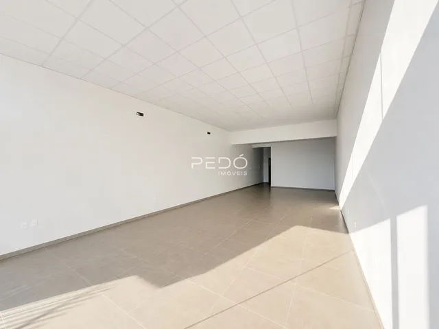 Vista de um corredor interno com piso de cerâmica claro.