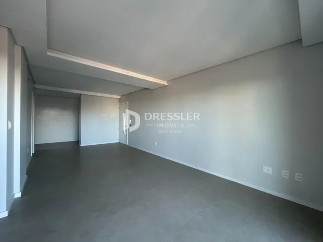 Hall de entrada amplo com piso de concreto cinza claro.