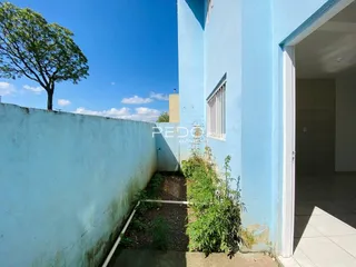Vista externa da fachada de um imóvel azul em Lajeado, Brasil, com muro lateral e vegetação.