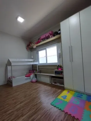 Foto interna de um cômodo com piso de madeira e armários brancos.