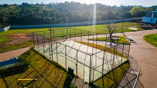 Vista externa de um campo esportivo cercado por uma cerca em uma propriedade.