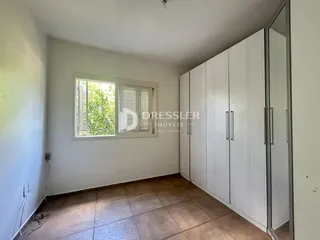 Ambiente interno de um cômodo com piso de cerâmica e armários embutidos.