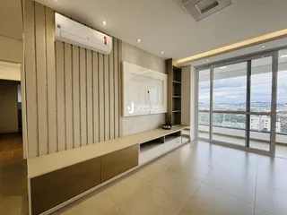 A sala de estar apresenta um ambiente moderno com piso claro e grandes janelas.