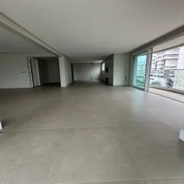 Vista interna de um espaço amplo com piso claro e paredes brancas.
