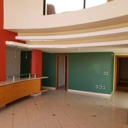 Vista interna de um espaço com paredes verdes e estrutura curva.