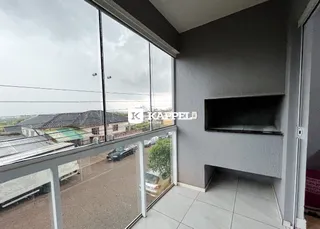 Ambiente interno com grandes janelas que oferecem vista para uma área externa pavimentada.
