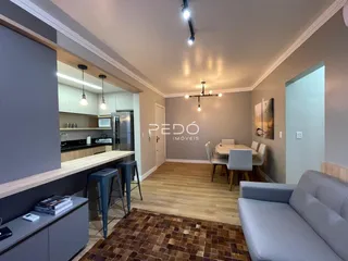 Ambiente moderno de sala de estar e jantar com piso de madeira.