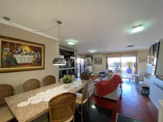 Uma sala de jantar com mesa de madeira e cadeiras de vime.