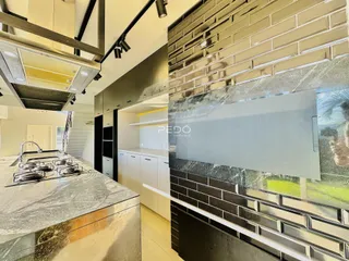 Uma cozinha moderna com bancada de granito e revestimento de tijolos.