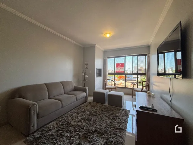 Sala de estar com sofá e vista para a cidade através da janela.