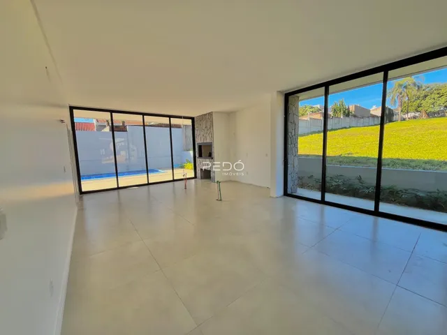 Sala de estar com grandes portas de vidro que dão vista para o jardim.