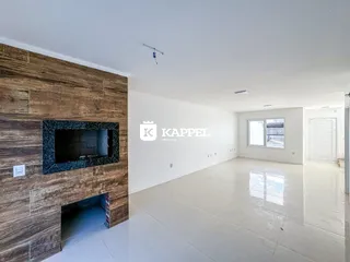 Sala de estar ampla com lareira em parede de pedra.