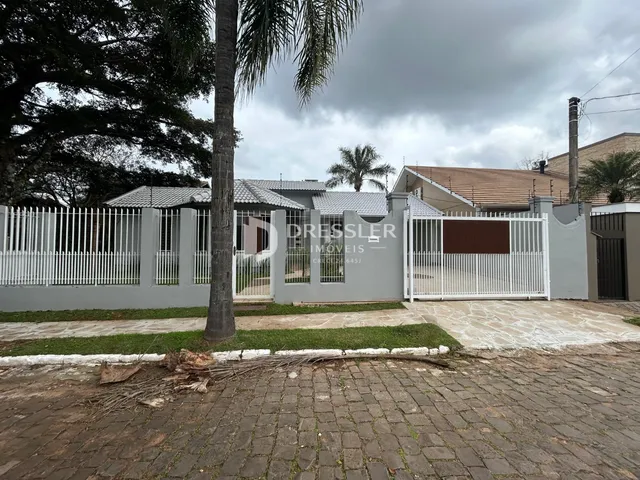 Fachada de uma residência em Lajeado, Brasil, com cerca e portão brancos.