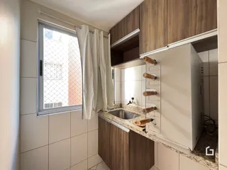 Foto de uma cozinha com armários de madeira e bancada de mármore.