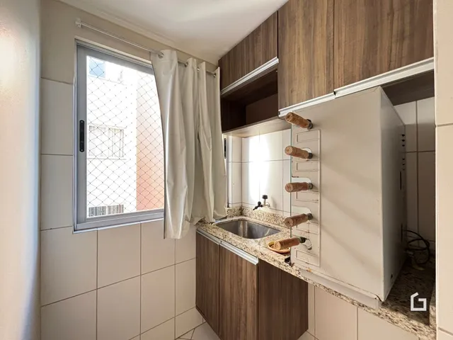 Foto de uma cozinha com armários de madeira e bancada de mármore.