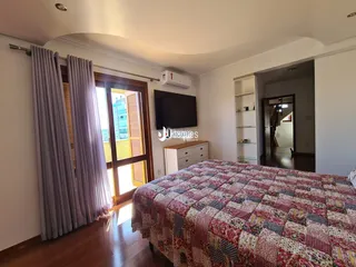 Quarto com cama e porta de vidro de madeira.