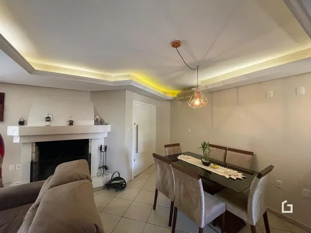 Sala de estar com lareira e mesa de jantar em um apartamento.