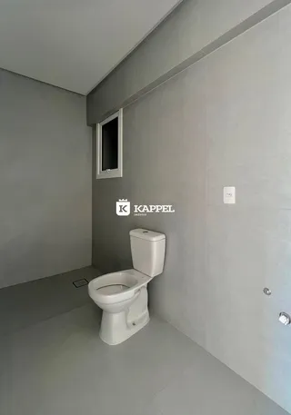 Foto de um banheiro interno com um vaso sanitário branco.