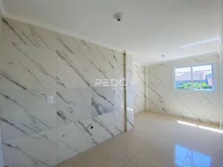 Ambiente interno com revestimento de mármore nas paredes e piso claro.