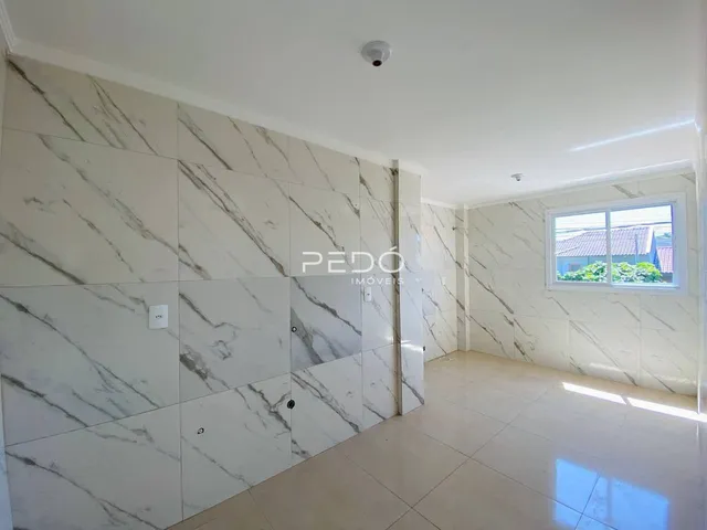 Ambiente interno com revestimento de mármore nas paredes e piso claro.