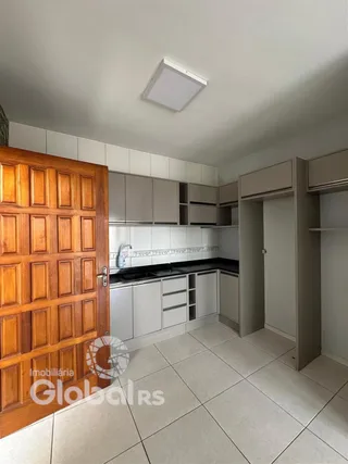 Foto de uma cozinha com armários de madeira e piso cerâmico.