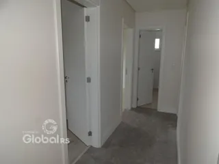 Hall de entrada com portas brancas em uma residência.