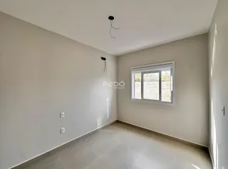 Vista interna de um cômodo com paredes brancas e piso claro.