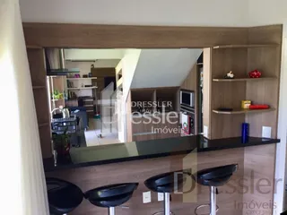 Vista interna de uma sala com painéis de madeira e estantes em Lajeado.