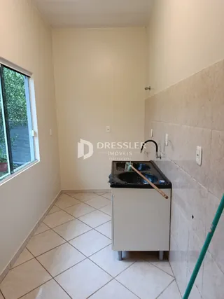Vista interna de uma área com piso de cerâmica e bancada.