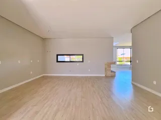 Ambiente interno amplo com piso de madeira clara.