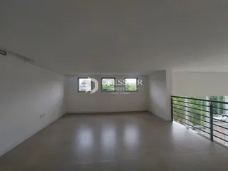 Interior de uma sala de estar com paredes brancas e piso claro.