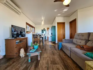Sala de estar com piso de madeira e sofá grande.