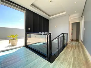 Sala de estar com piso de madeira e vista para o exterior da residência.