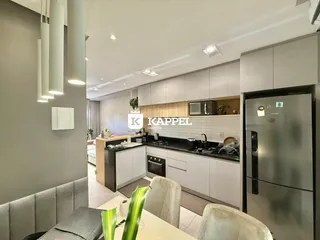 Cozinha moderna com armários claros e bancadas escuras.