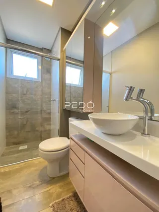 Foto de um banheiro com box de vidro e pia moderna.