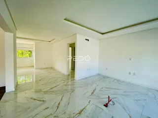 Ambiente interno amplo com piso de mármore claro e paredes brancas.