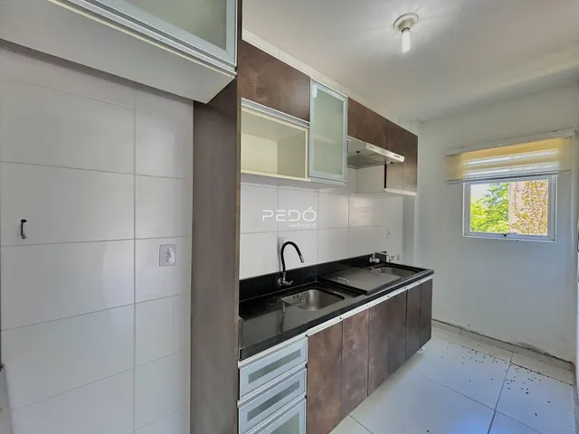 Cozinha com armários marrons e revestimento branco.