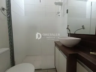Um banheiro moderno com box de vidro e bancada de madeira.