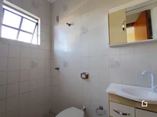 Foto interna de um banheiro com azulejos brancos.