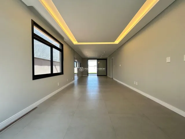 Foto de um corredor longo com iluminação embutida e janela na parede.