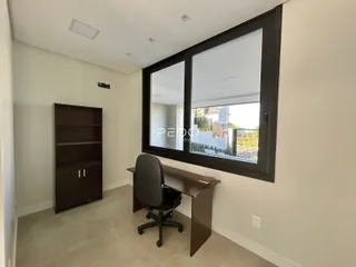 Um cômodo interno com estante de madeira e grande janela.