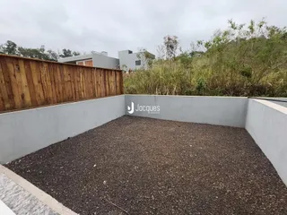 Vista externa de um pátio com muro e cerca de madeira.